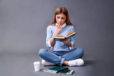 Öğrenci katta oturan kitap okuma. Öğrenci kavram. Stüdyo