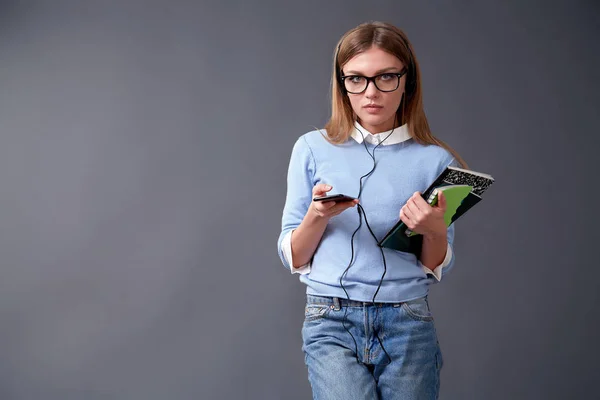 Diák gazdaság smartphone és jegyzetfüzet. Student fogalma. Stúdió — Stock Fotó