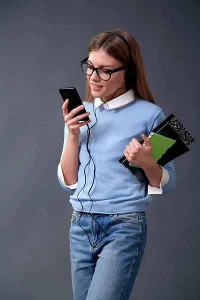 Студент держит смартфон и блокноты. Концепция студента. Студия — стоковое фото