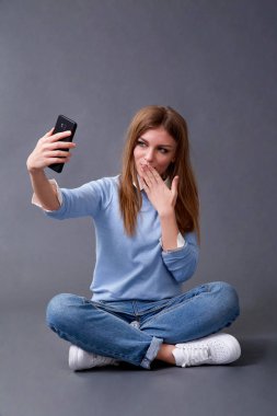 Genç mutlu öğrenci kız katta oturan paketleri ile.