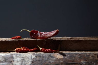 Kurutulmuş biber siyah bir zemin üzerine ahşap kurullarında yalan. Görüntü. Yakın çekim.