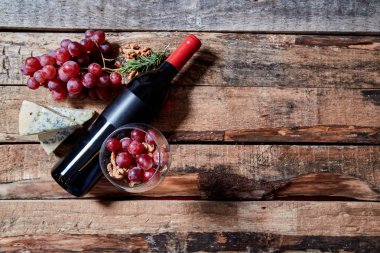 Şarap şişesi ile kokulu mavi peynir ve ekmek ile masada Olgun üzüm ile dolu Wineglass