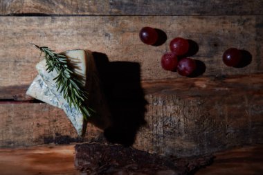 Üzüm ile ahşap masada biberiye ile gemide mavi peynir. Üst görünüm