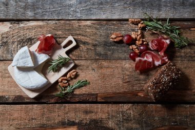 Ahşap masada peynir ve prosciutto ve ceviz ile lezzetli çeşitli meze
