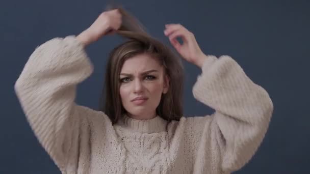 Портрет несчастной молодой женщины, расчесывающей волосы, смотрящей в камеру — стоковое видео