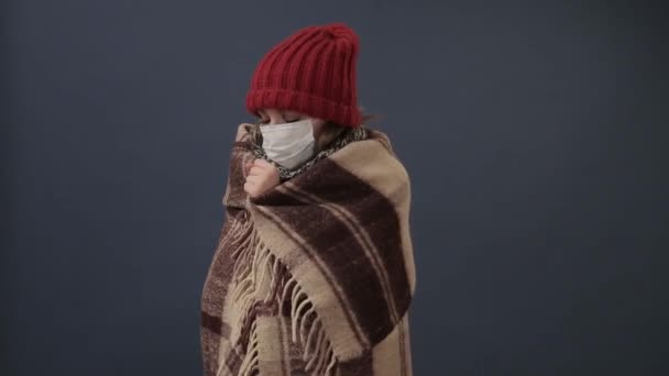 Chica enferma envuelta en una manta se enfría y febril — Vídeo de stock