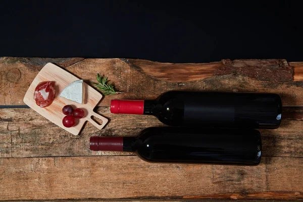Κορυφαία θέα των γευμάτων που σερβίρονται στο σκάφος με κλαδί δενδρολίβανο και μπουκάλια κόκκινου κρασιού σε ξύλο — Φωτογραφία Αρχείου