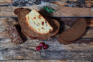 Birkaç üzüm ile ahşap kalaslar üzerinde dilimler halinde çeşitli taze pişmiş ekmek üst görünümü.
