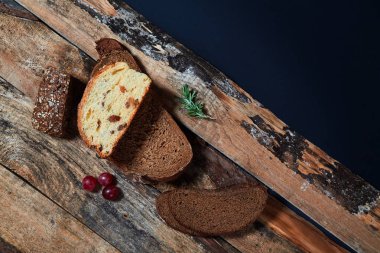 Birkaç üzüm ile ahşap kalaslar üzerinde dilimler halinde çeşitli taze pişmiş ekmek üst görünümü.