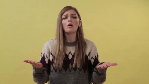 Young surprised girl standing isolated over yellow background while looking camera — 비디오