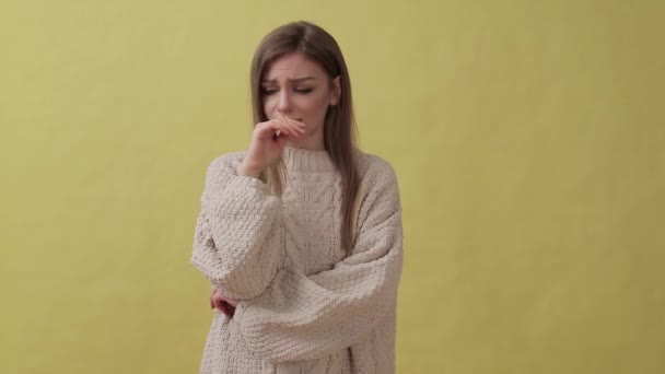 Jeune fille déçue debout isolé sur fond jaune tout en regardant caméra — Video