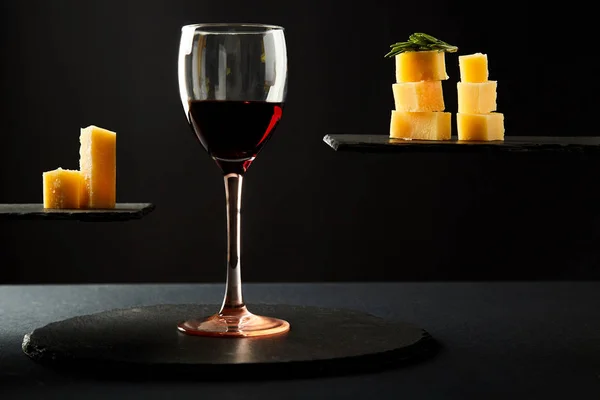 검은 배경에 레드 와인과 치즈 조각의 유리 — 스톡 사진