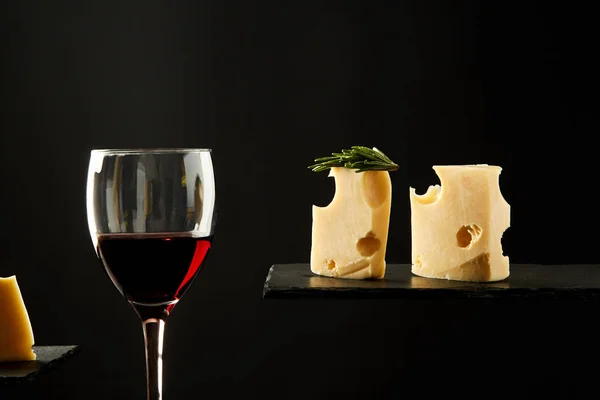 Zoete rode wijn in glas en verse druiven bessen op zwarte achtergrond — Stockfoto