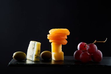 Siyah zemin üzerinde Zeytin peyniri üzüm ve diğer çeşitli geleneksel mezeler.