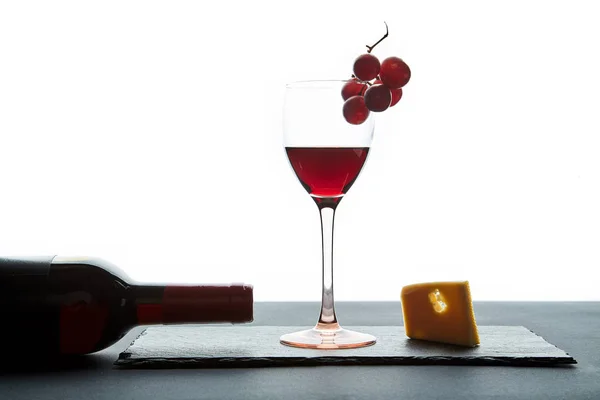 Glas rode wijn naast fles en traditionele voorgerecht op witte achtergrond — Stockfoto
