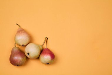 Olgun sulu armut turuncu arka plan üzerine yerleştirilir. Renkli meyve deseni veya arka plan.