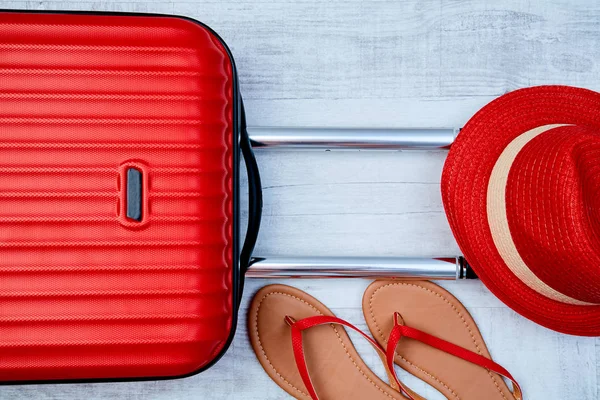 From above red suitcase beside flip-flop on light background. Travel blogging or woman blogger or summer vacation conception. — Stock Photo, Image