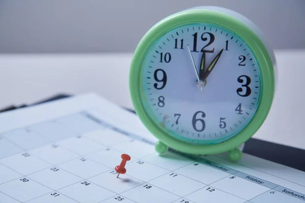 Time management, deadline and schedule concept: alarm clock and pushpin on schedule plan — Stock Photo, Image