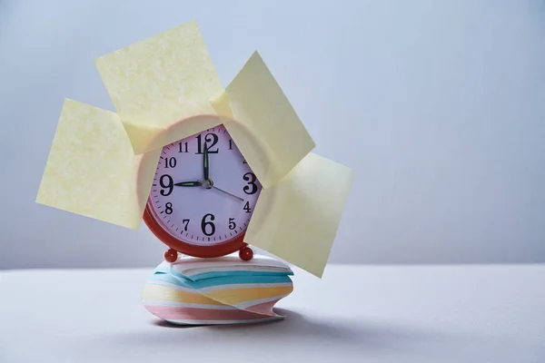 Termine di gestione del tempo e concetto di pianificazione: orologio con adesivi sulla pila di adesivi — Foto Stock