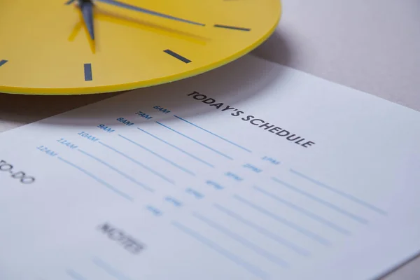 Plazo de gestión del tiempo y concepto de horario: reloj amarillo en el fondo del calendario — Foto de Stock