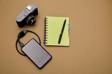 Bloglama, blog ve blogger veya sosyal medya kavramı: not defteri, retro fotoğraf makinesi ve arka planda harici sabit disk. Düz yatıyordu.