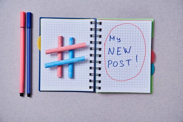 Блог, блогер або концепція соціальних медіа: блокнот і символ хештегу на сірому фоні — стокове фото
