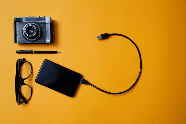 Bloglama, blog ve blogger veya sosyal medya kavramı: gözlük, fotoğraf makinesi ve sarı bir arka plan üzerinde harici bir sabit disk. Düz yatıyordu — Stok fotoğraf