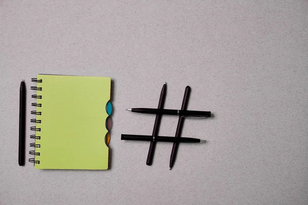 Блог, блогер або концепція соціальних медіа: блокнот і символ хештегу на сірому фоні — стокове фото