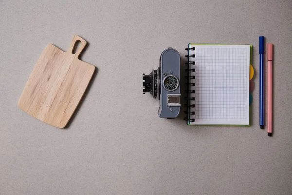 Food blogging, blog and blogger or social media concept: notepad and a retro photo camera on a grey background. Flat lay