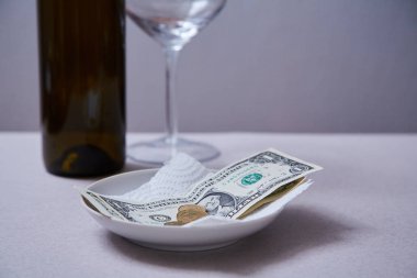 Restoran ipuçları veya bahşiş. Bir tabakta banknotlar ve madeni paralar