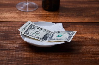 Restoran ipuçları veya bahşiş. Bir tabakta banknotlar ve madeni paralar