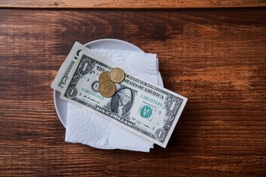 Restoran ipuçları veya bahşiş. Bir tabakta banknotlar ve madeni paralar