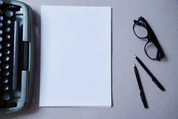 Література, автор і письменник, концепція письма і журналістики: друкарська машинка і окуляри і чистий аркуш паперу — стокове фото
