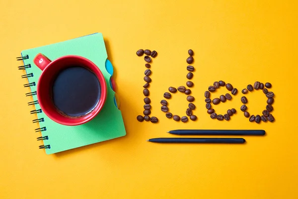 Kreativní, bystrý nápad, inovace nebo inspirace. Nápis zrnka kávy na žlutém pozadí. — Stock fotografie