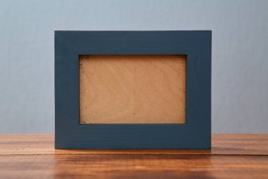 Ahşap bir arka plan üzerine bir resim veya yazıt eklemek için alan ile ahşap fotoğraf çerçevesi. Mavi arka plan. Alay etmek.