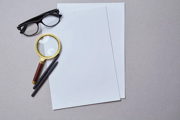 Magnifying glass lying on the paper. Analysis and analytic concept. Copy space. Mockup