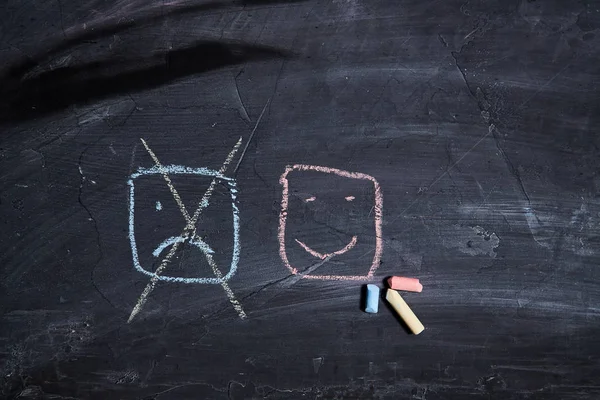 Pozitif düşünme veya Tutum ve Mutlu Kavram. El Çizilmiş Bir Gülen Yüz Ve Üzgün Duygu tebeşir üzerinde