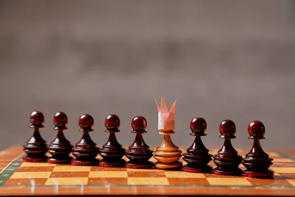 Juego de negocios, trabajo en equipo, líder y concepto de competencia. Un peón de ajedrez con una corona en la cabeza —  Fotos de Stock