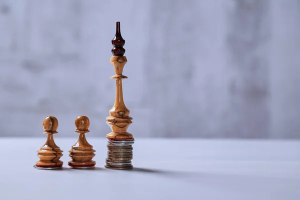 Líder, crecimiento, finanzas e inversión, desarrollo y concepto de mercado de valores. Rey de ajedrez en una pila de monedas y peones . —  Fotos de Stock