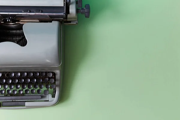 Retro maszyna do pisania na zielonym tle. Autorstwo. Dziennikarstwo. Maszyna ręczna z kluczami do maszyn do pisania, przestrzeń do kopiowania — Zdjęcie stockowe