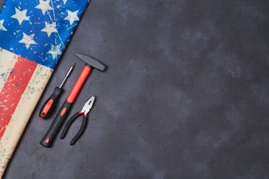 İşçi Bayramı. İşçi bayramı. İşçi bayramı. Amerikan bayrağı, arka planda tamir aletleri. Selamlama şablonu, alanı kopyala