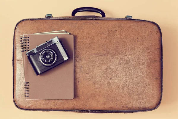 Antecedentes de viagem. Viagem vintage. Blogar. Vista superior da mala de couro retro com bloco de notas e câmera, espaço de cópia — Fotografia de Stock