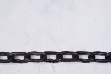 Siyah metal zincir beyaz desenli arka planda izole edilmiş. Nesneleri bağlamak veya emniyete almak için bağlı bağlantılar, boşluğu kopyala
