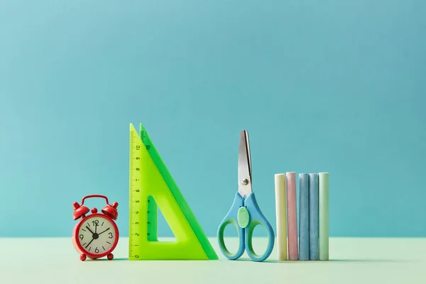 Kırtasiye seti. Cetvel, makas, pastel boya ve çalar saat, kopyalama alanı. Geçmişi öğrenme zamanı. Okul konseptine dönelim..