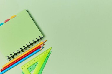 Kırtasiye seti yeşil arka planda. Okula dönelim. Okulun başlangıcı. Yeni akademik yıl. Okul malzemeleri, kopyalama alanı
