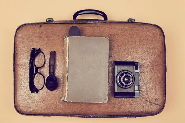 Mala velha, óculos, livro e cachimbo de fumar e câmera. Antecedentes de viagem. Os avós viajam. Viagem vintage . — Fotografia de Stock