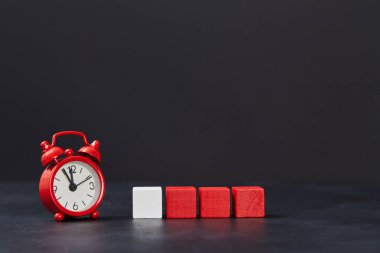 Kırmızı küpler siyah arka planda bir beyaz ve alarm saati ile aynı hizada, boşluğu kopyala. Satış zamanı. Gece satışı. Kara Cuma