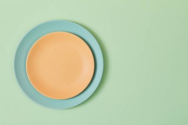 Yeşil üzerine izole edilmiş boş tabak ve peçete üst görünümü, kopyalama alanı. Masa ayarı. Kutlama konsepti. Tatil etkinliği.