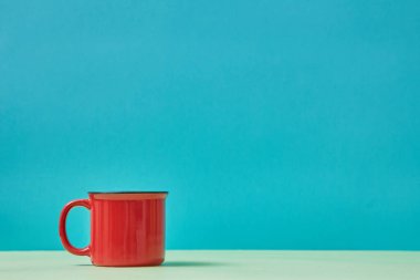 Kırmızı bardak. Masa takımı. Çatal bıçak. Çay zamanı. Mavi arka planda parlak bir kupa. İçecek kabı. Uzayı kopyala Model biçimi