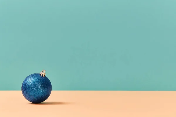С Новым годом. Зимние каникулы. Концепция Рождества. Мяч с блестками. Копировать место для текста. Изолированный на синем фоне — стоковое фото